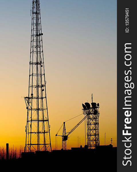 Cell tower construction over sunset