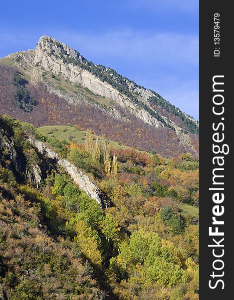 Autumnal forest and rocky peak in the Pyrenees, Spain