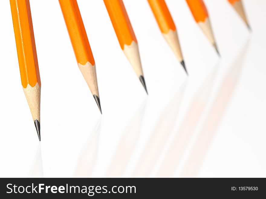 Few wooden yellow pencils standing in a row on white background