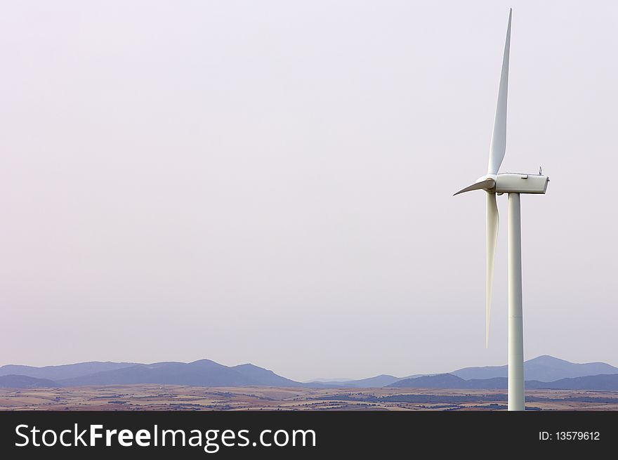 Lone windmill with a white sky in a dry landscape. Lone windmill with a white sky in a dry landscape