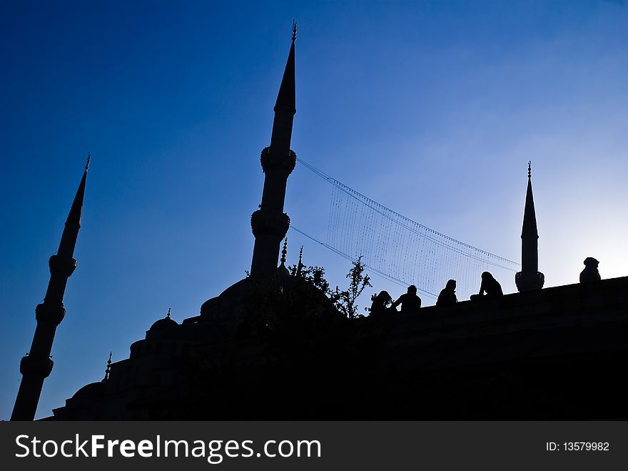 The silhouette of the blue mosque in Istanbul, Turkey, with people talking. The silhouette of the blue mosque in Istanbul, Turkey, with people talking