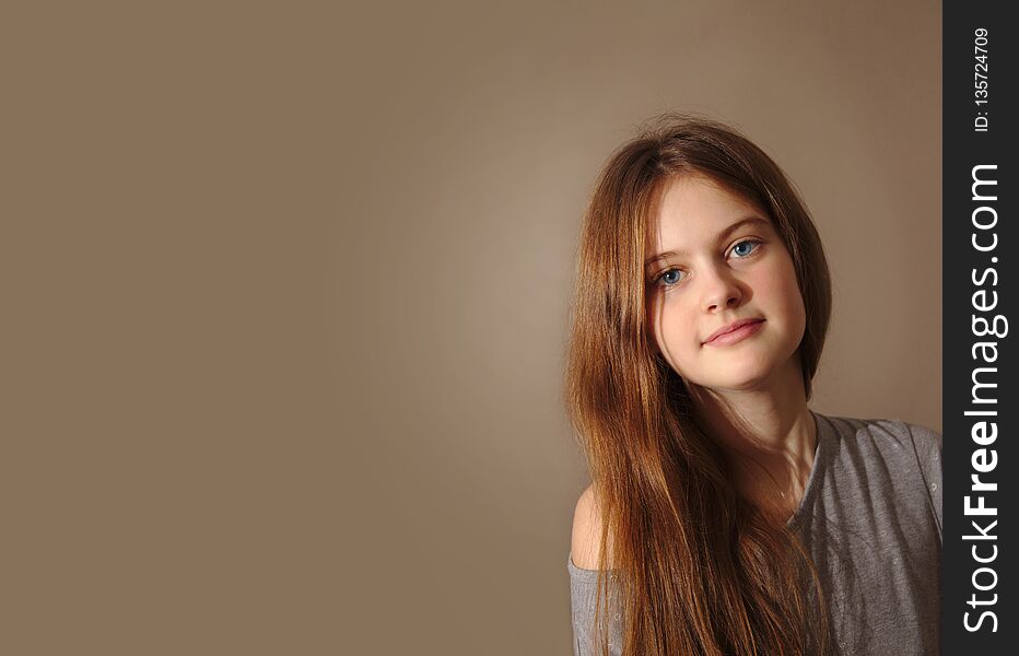 Blue eyed brown haired shy girl with flowing hair on background