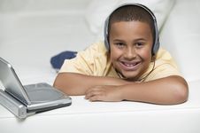 Boy On Sofa Watching Movie On DVD Player Stock Images