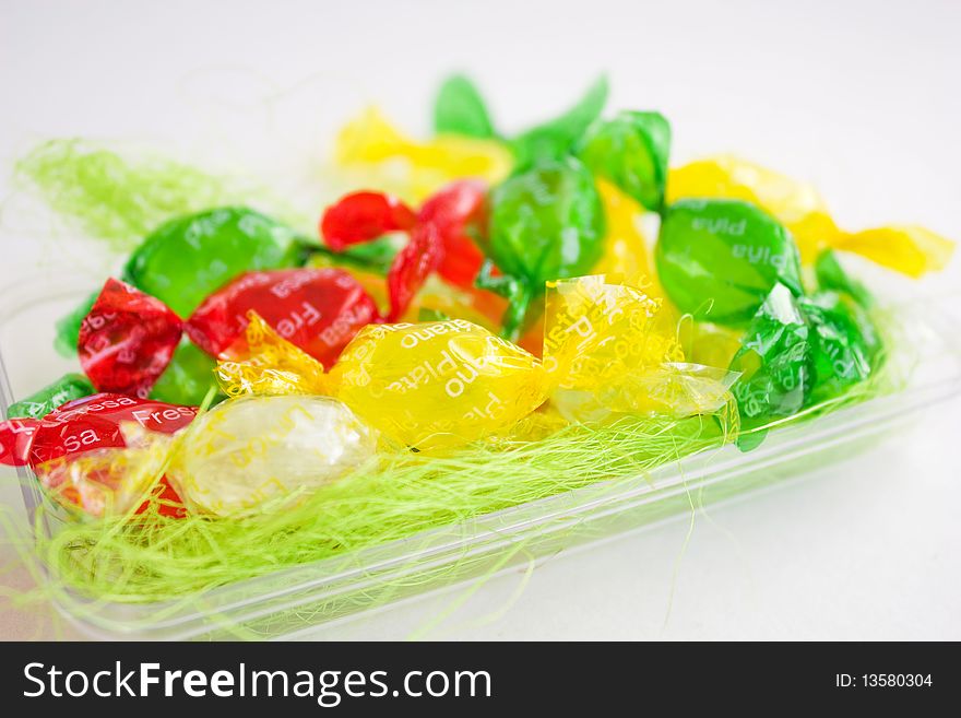 Multi-colored sweetmeats in a box on a white background