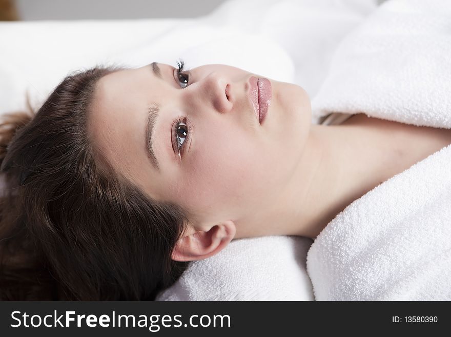 Beautiful young women in the spa, looking at camera, brunette, wearing white towel robe. Beautiful young women in the spa, looking at camera, brunette, wearing white towel robe.