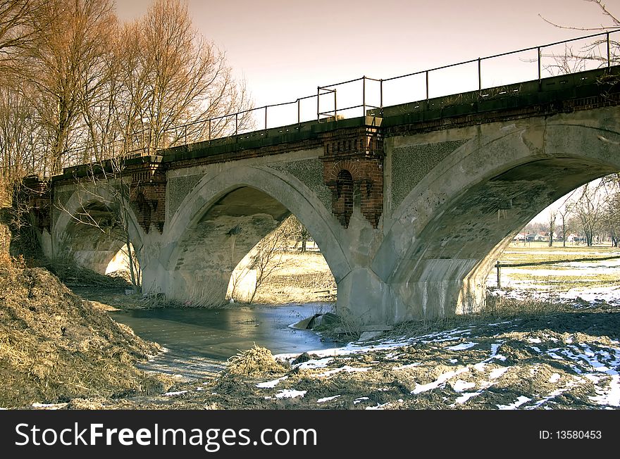 Old stone bridge with three arches of passage.