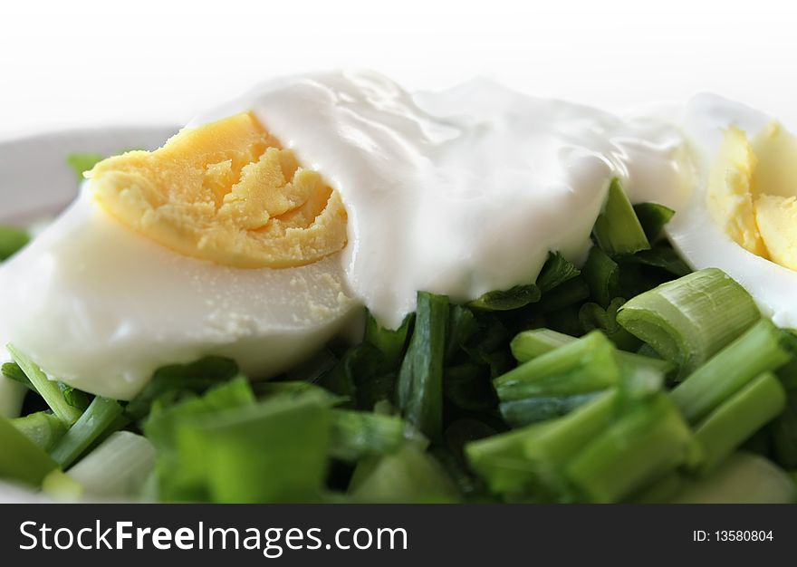 Salad with green onion and egg in a plate
