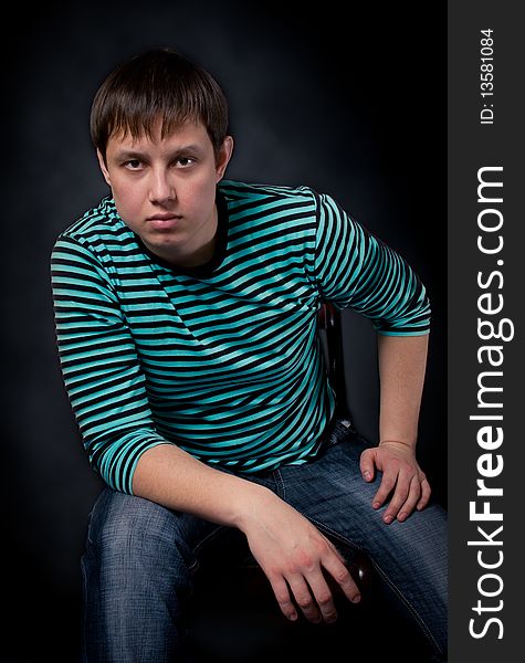 The young man sitting on a chair. The young man sitting on a chair