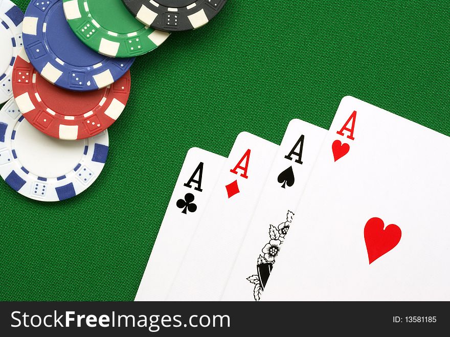 Poker hand four aces with chips on green felt