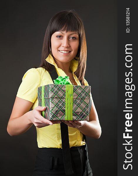 Girl with a gift against a dark background. Girl with a gift against a dark background