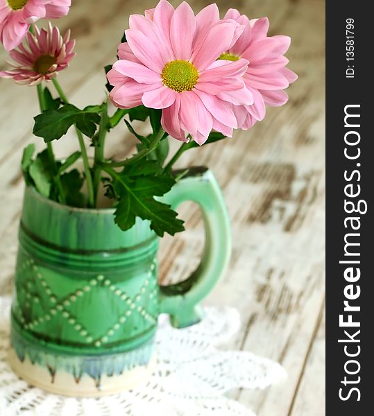 chrysanthemums in old ceramic mug on wooden. chrysanthemums in old ceramic mug on wooden