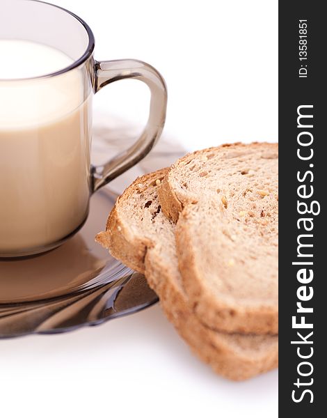 Bread and cup of milk on a white background (blurred)