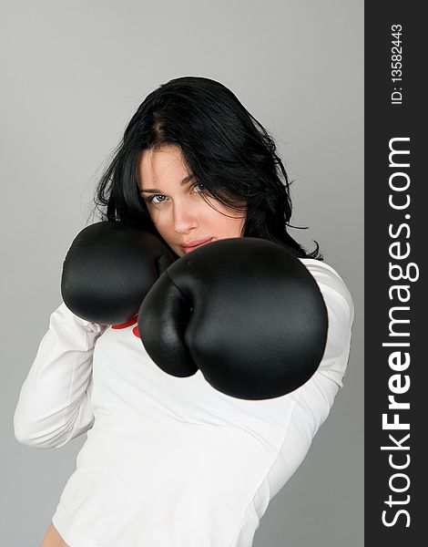 A young woman in black boxing gloves. A young woman in black boxing gloves