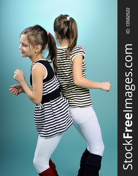 White twins having fun and dancing, turquoise background. White twins having fun and dancing, turquoise background