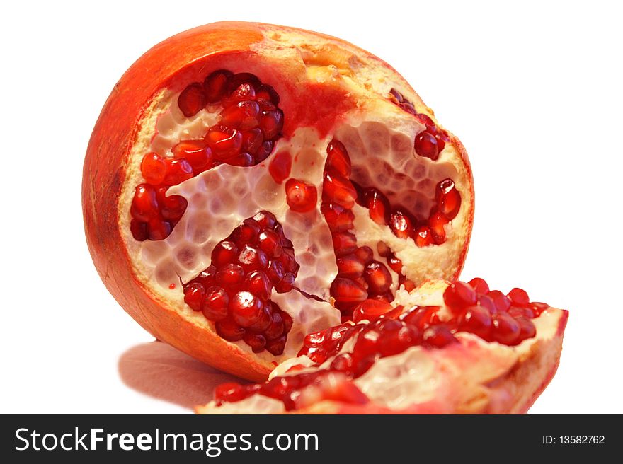Ripe pomegranate razlomlen into two parts, inside the fruit ripe pomegranate seeds bright red. Ripe pomegranate razlomlen into two parts, inside the fruit ripe pomegranate seeds bright red