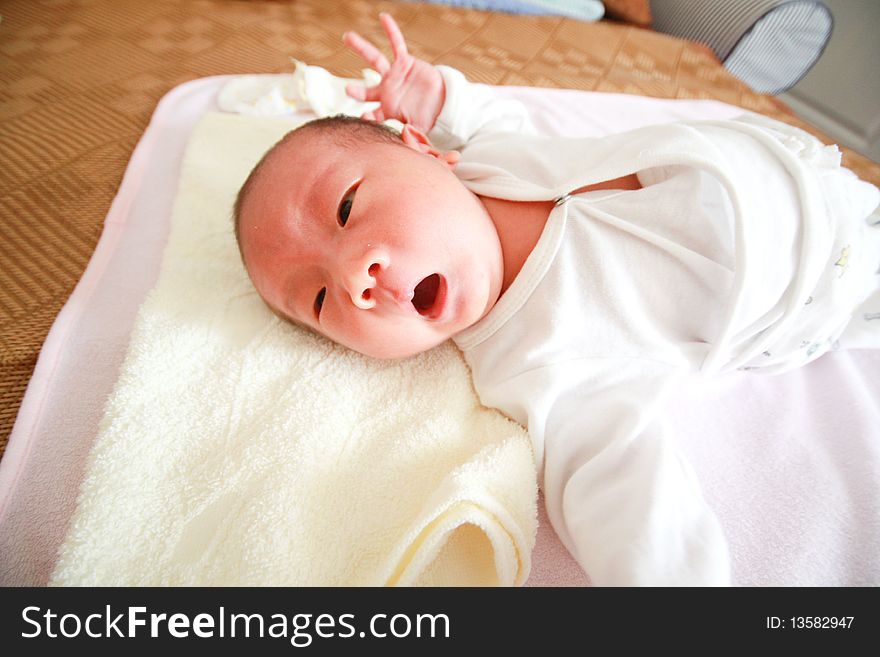 A yawning chinese baby on bed. A yawning chinese baby on bed