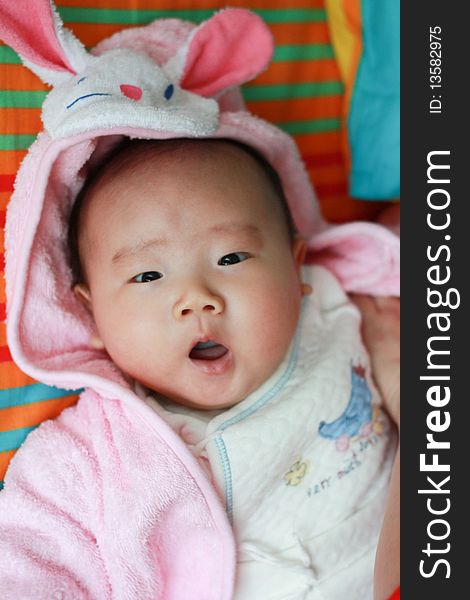 A yawning chinese baby with rabbit hat. A yawning chinese baby with rabbit hat