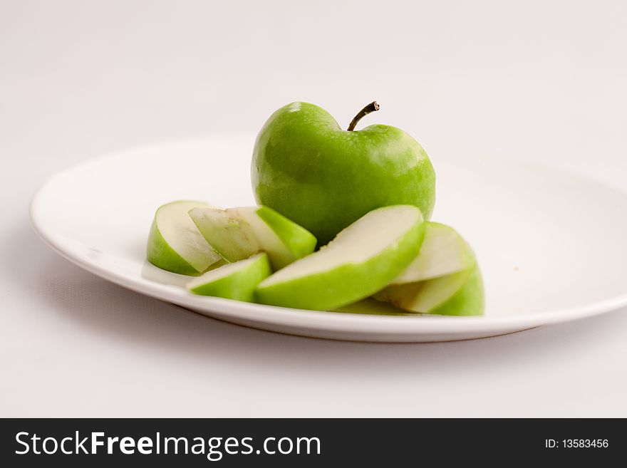 Sliced Apple on plate against white background