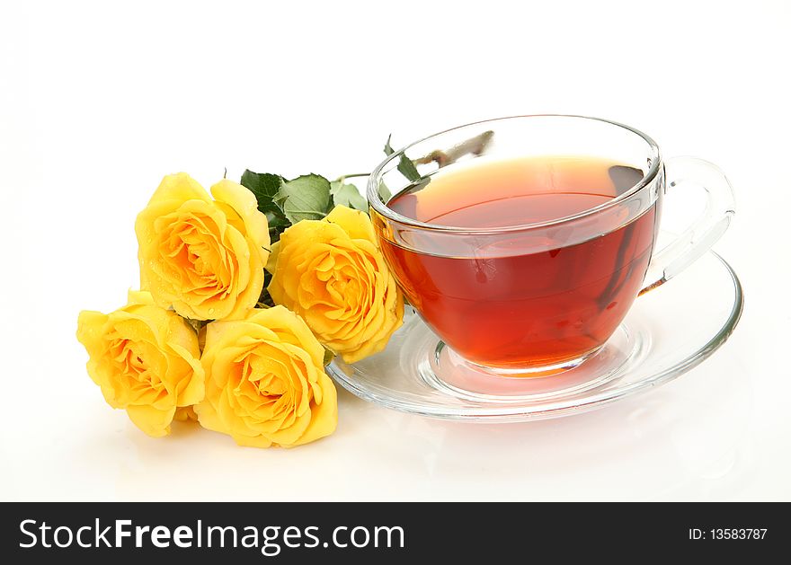 Tea and yellow roses on a white background