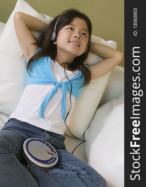 Girl lying in bed Listening to Music on CD Player, close up