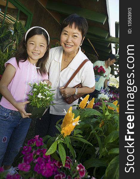 Grandmother and granddaughter in plant nursery, portrait. Grandmother and granddaughter in plant nursery, portrait