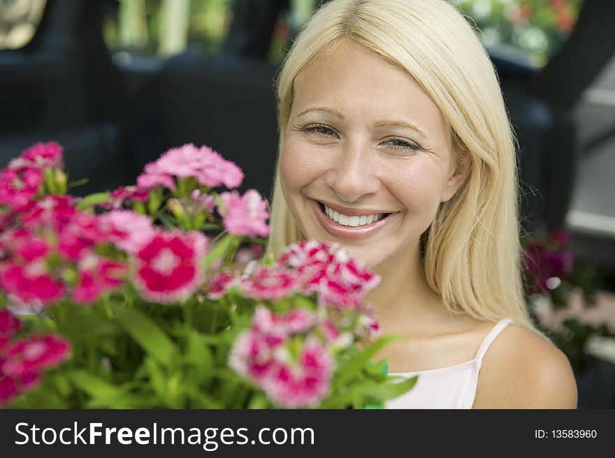 Woman Holding Flowers in front of minivan, portrait
