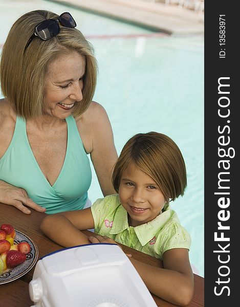 Girl (7-9) with grandmother at pool, portrait. Girl (7-9) with grandmother at pool, portrait.