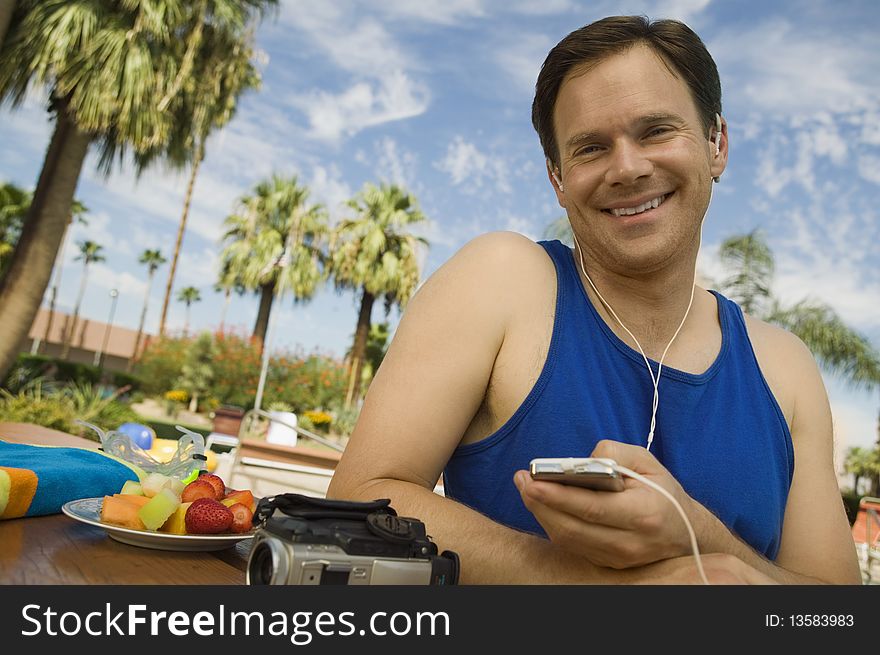 Man Listening to MP3 Player outdoors, portrait.