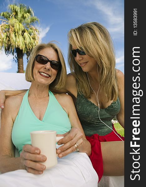 Two women sitting on sunlounger