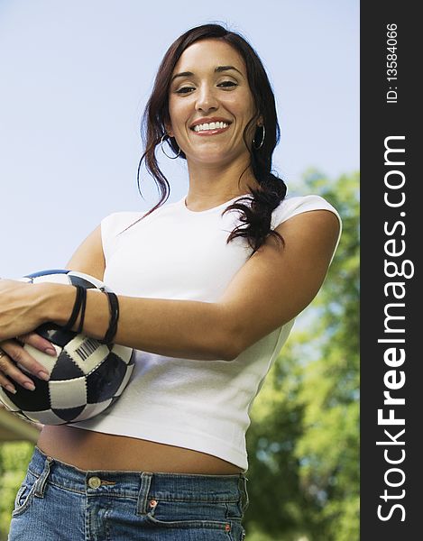 Woman Holding Soccer Ball, low angle portrait.