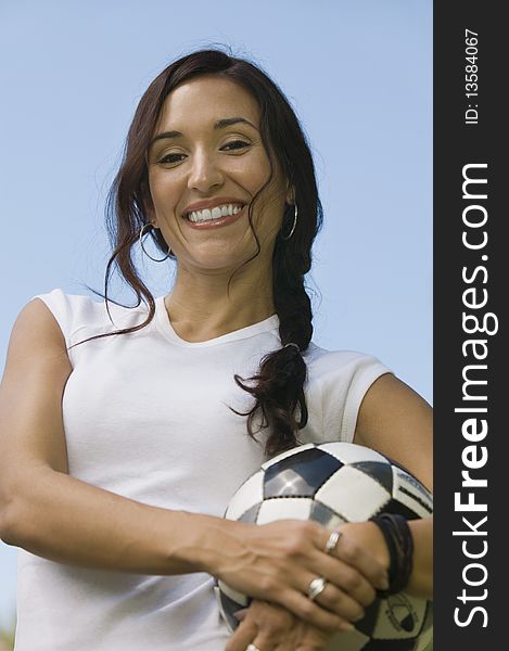 Woman Holding Soccer Ball, low angle portrait.