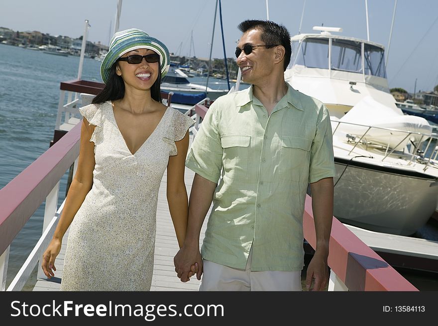 Asian ethnic Couple holding hands on docks