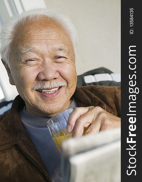 Man drinking orange juice, (portrait)