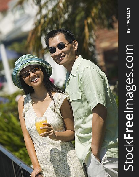 Couple with orange juice, outdoors, (portrait)