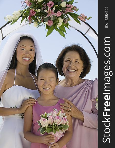 Bride with mother and sister, outdoors, (portrait)