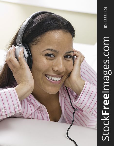 Woman Lying On Sofa Listening To Music