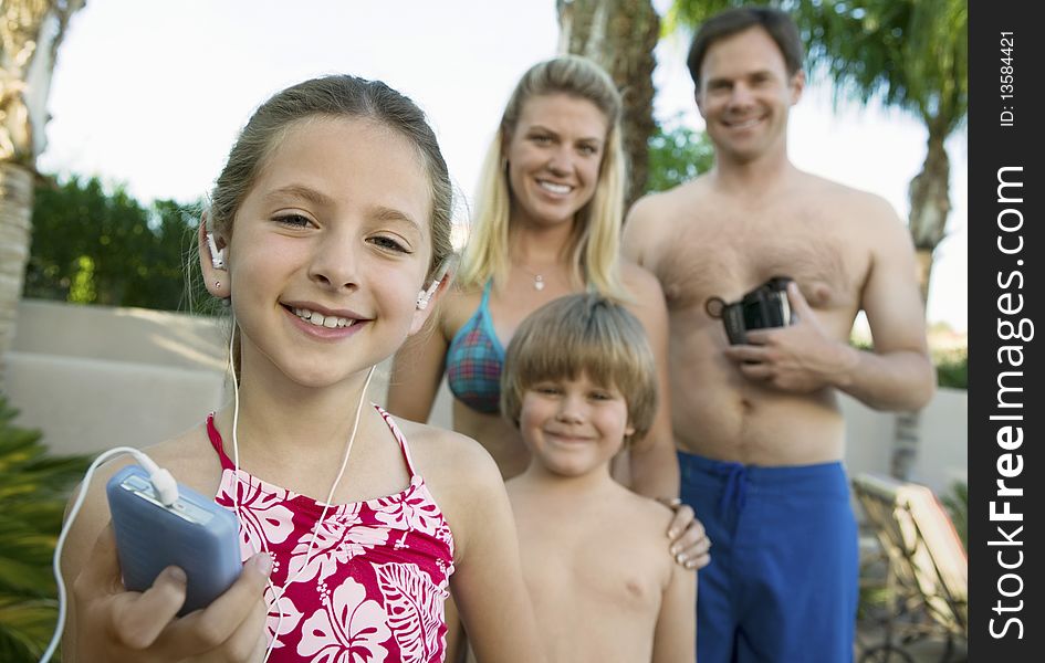 Girl Listening to MP3 Player Standing with Family. Girl Listening to MP3 Player Standing with Family