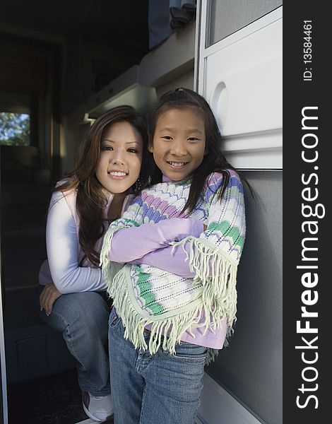 Asian ethnic Sisters standing inside RV