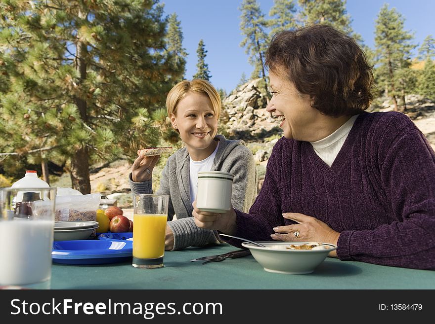 Women eating at picnic table in campground