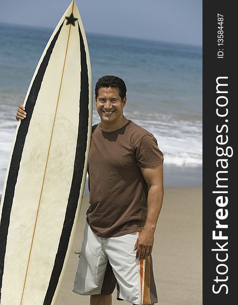 Man Holding Surfboard on beach