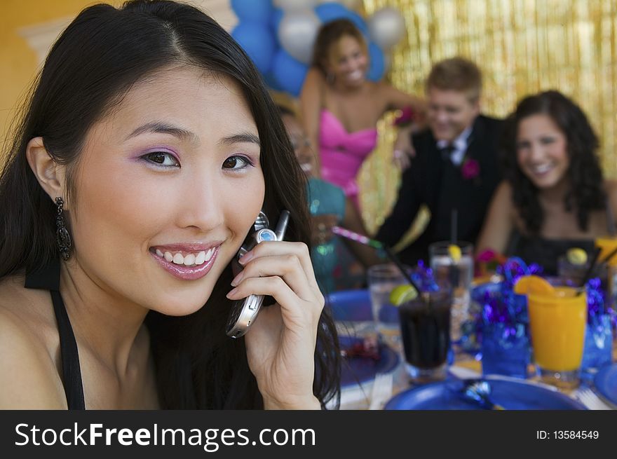 Teenager girl using cell phone at school dance