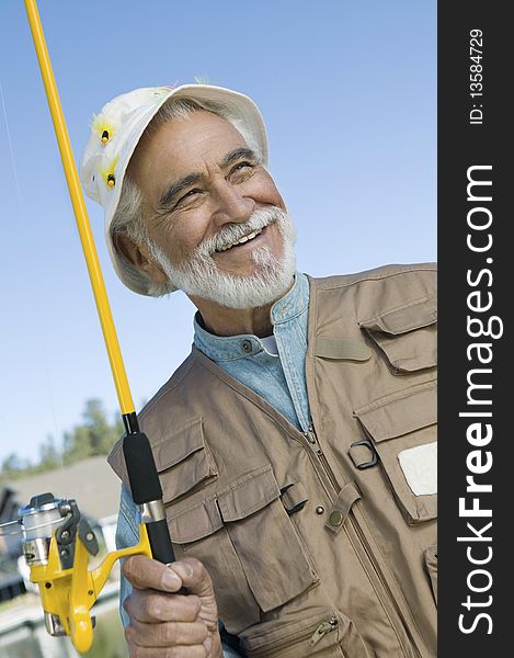 Middle-aged fisherman holding fishing rod outdoors. Middle-aged fisherman holding fishing rod outdoors