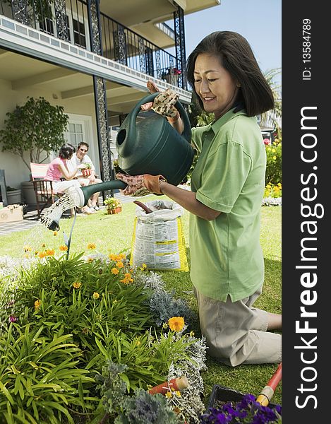 Woman watering plants in garden