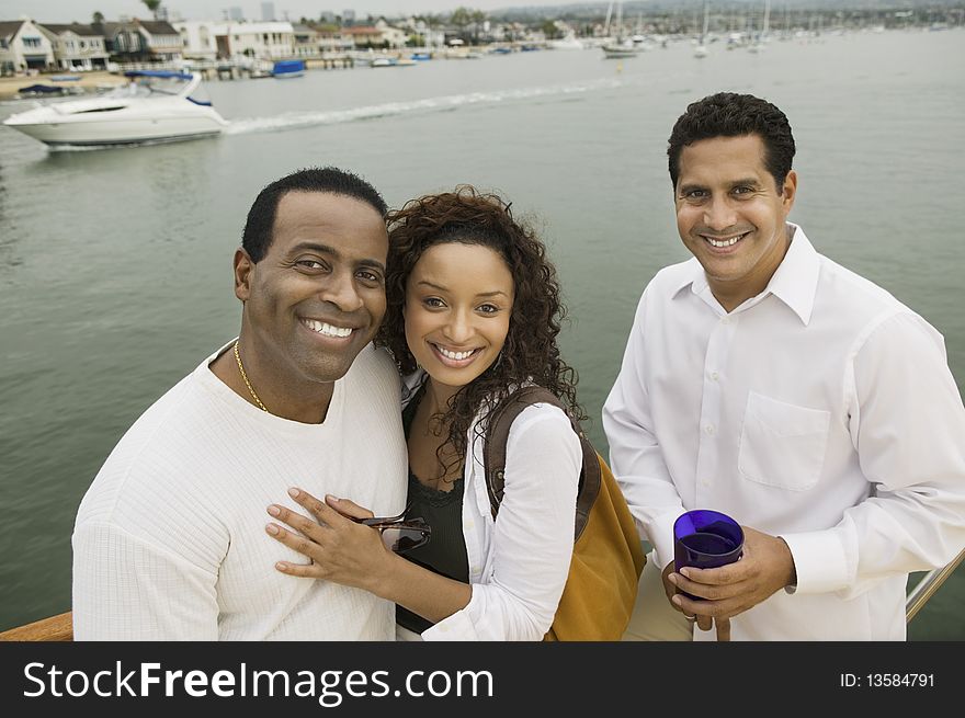 Couple with friend on yacht, (portrait), (elevated view)