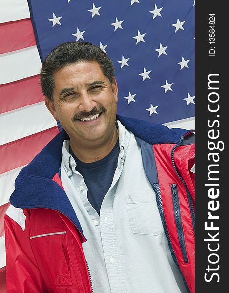 Man standing in front of American flag, (portrait)