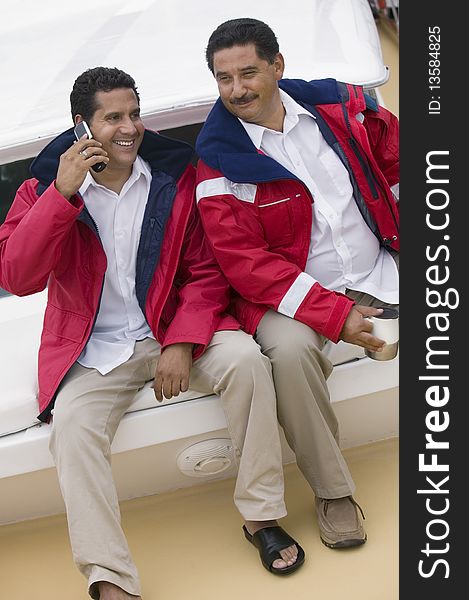 Two men relaxing on yacht, (elevated view)