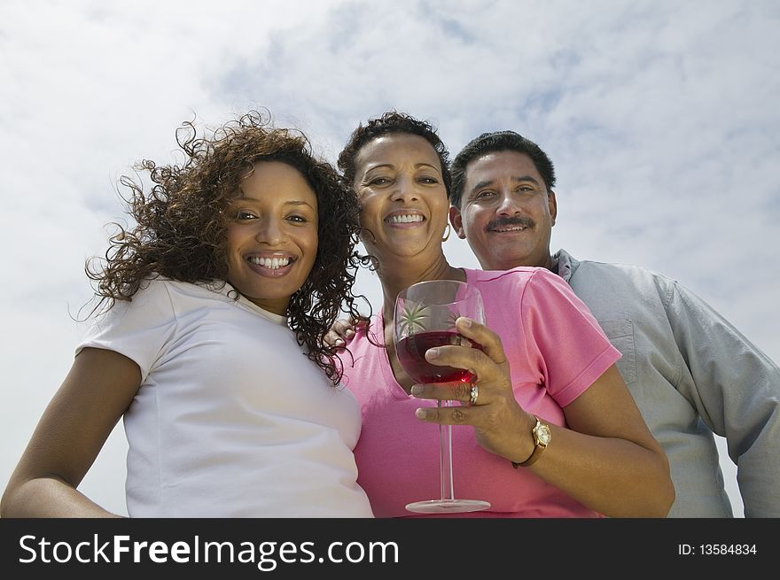 Couple with friend outdoors, (portrait), (low angle view)