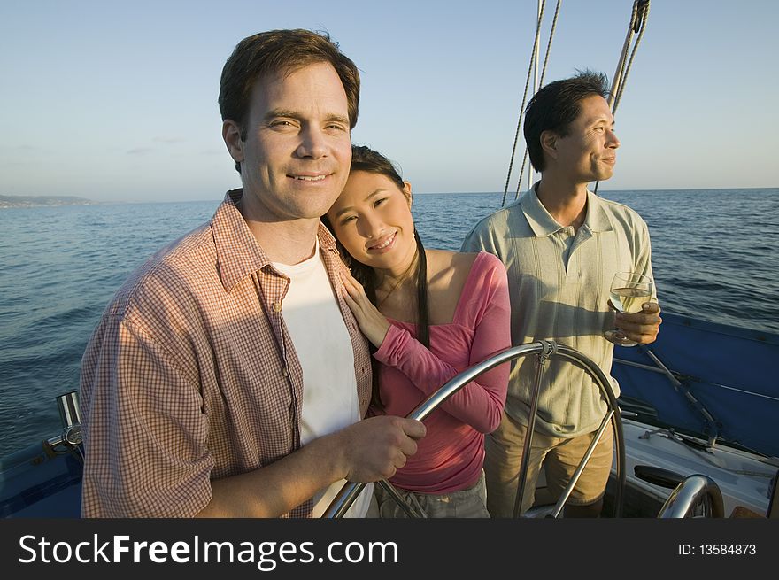 Couple with friend relaxing on yacht, (portrait)