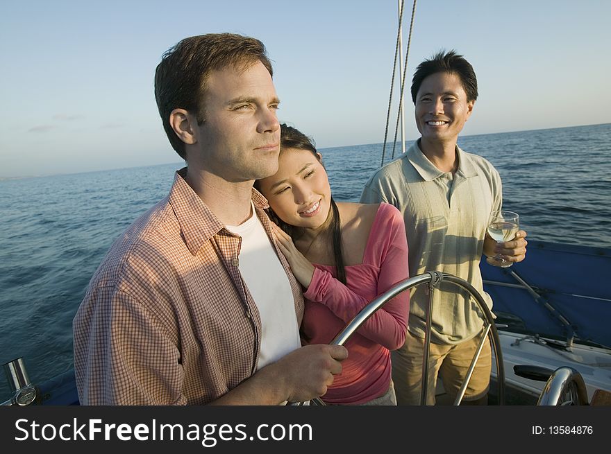 Couple with friend at steering on yacht. Couple with friend at steering on yacht