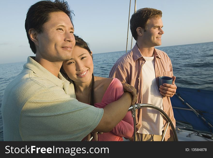 Couple with friend at steering on yacht. Couple with friend at steering on yacht